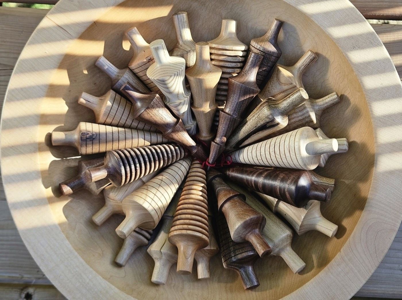 Tree ornaments in mixed woods arranged in a circle inside a bowl